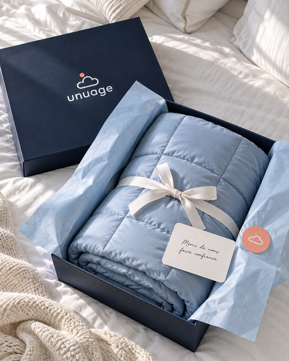 La boîte unuage ouverte avec la couette Cumulus, le papier de soie et la carte de remerciement